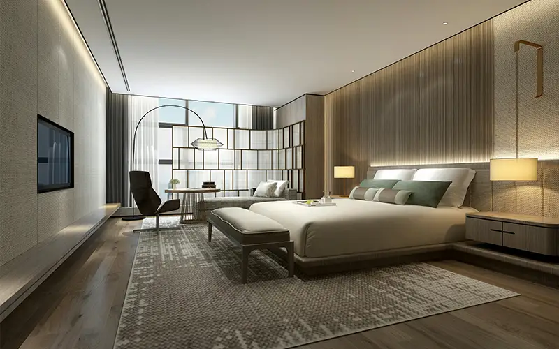 Modern hotel room with king bed, seating area, floor lamp, large window, and mounted flat-screen TV.