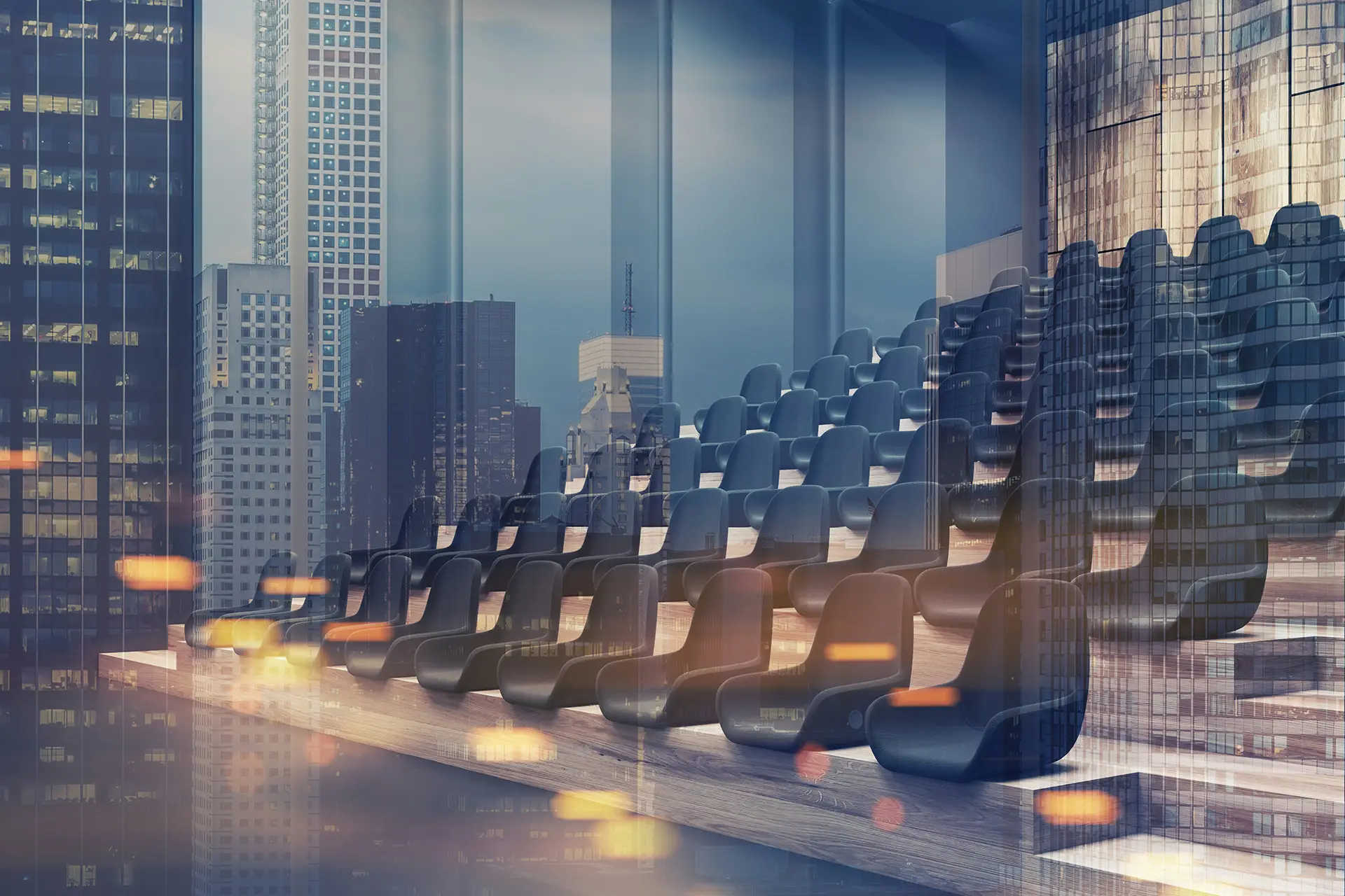 Empty modern auditorium seats with a city skyline reflected on glass walls in the background.